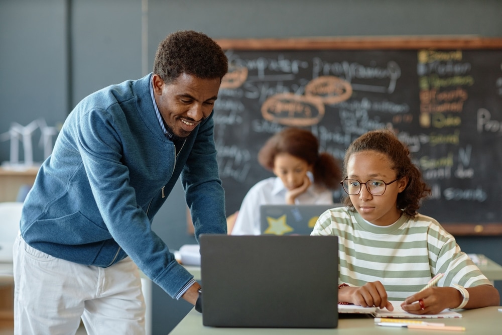 Portrait,Of,Friendly,Male,Teacher,Helping,African,American,Boy,During